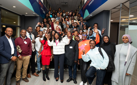 group of UCD African alumni, students, and mentors smiling and celebrating.